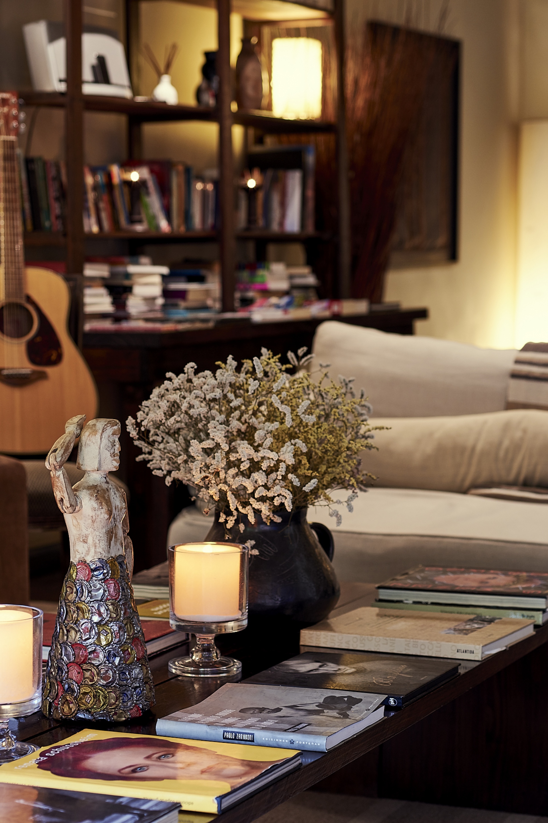 The living salon furnished with layered vintage rugs, art books, and Coppola family memorabilia without a museum-like feel.