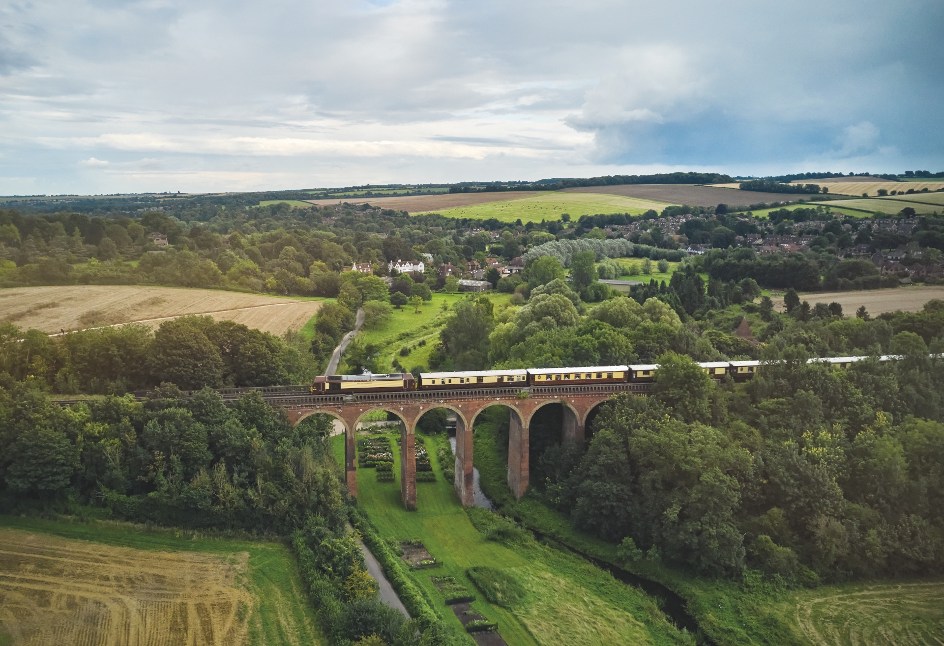 Exterior view of the vintage Belmond British Pullman train cars against the London countryside