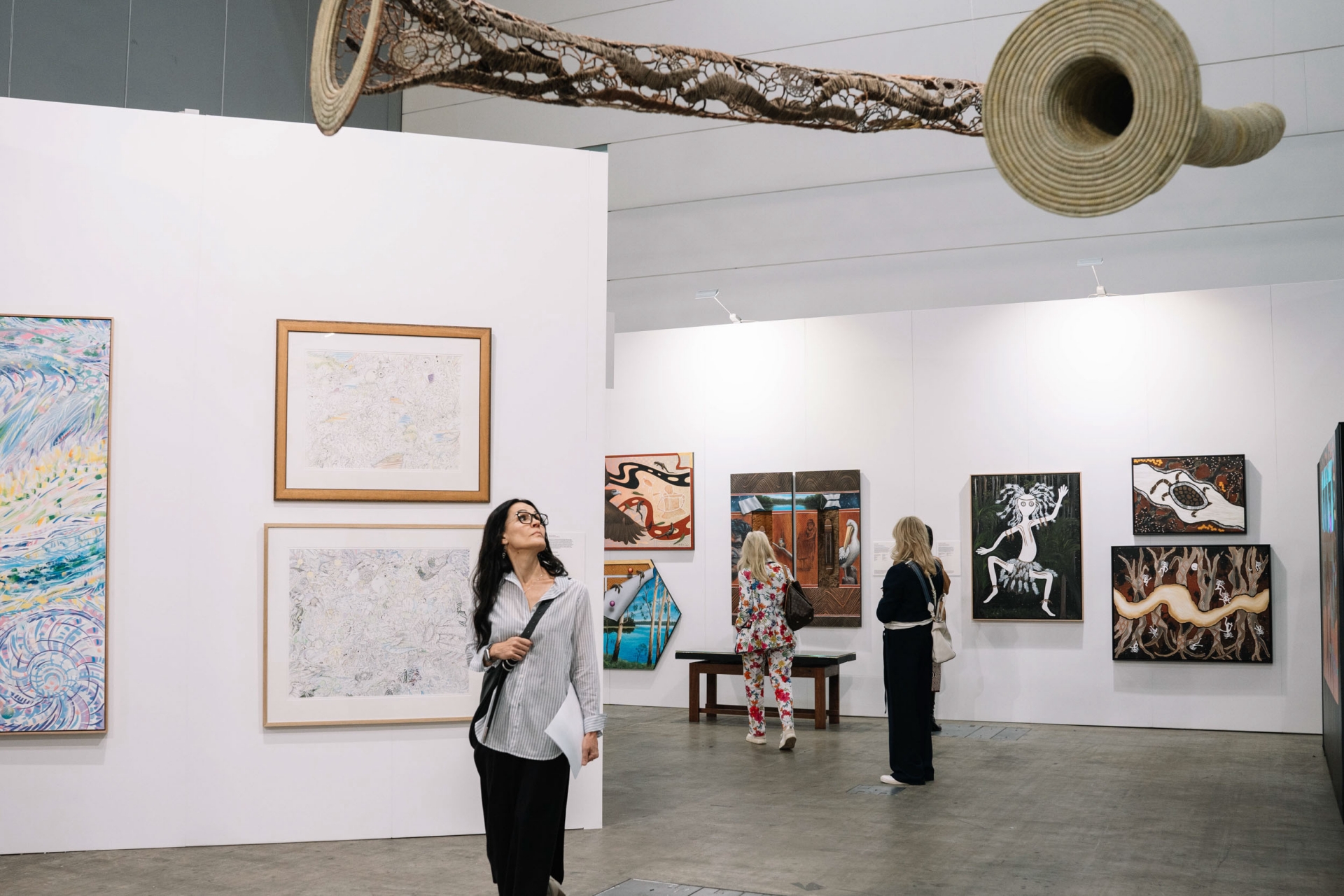 Visitors closely examining experimental sculptural works within the gallery space