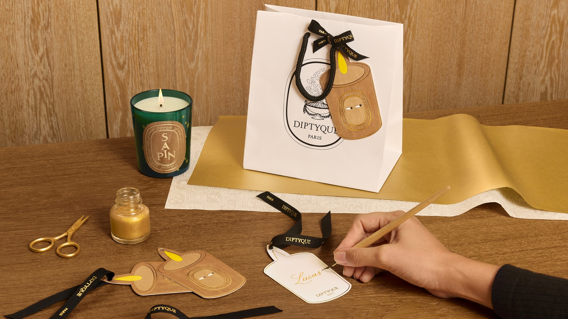 A collection of textured, hand-painted gold-accented taper candles styled for the Diptyque holiday tablescape.