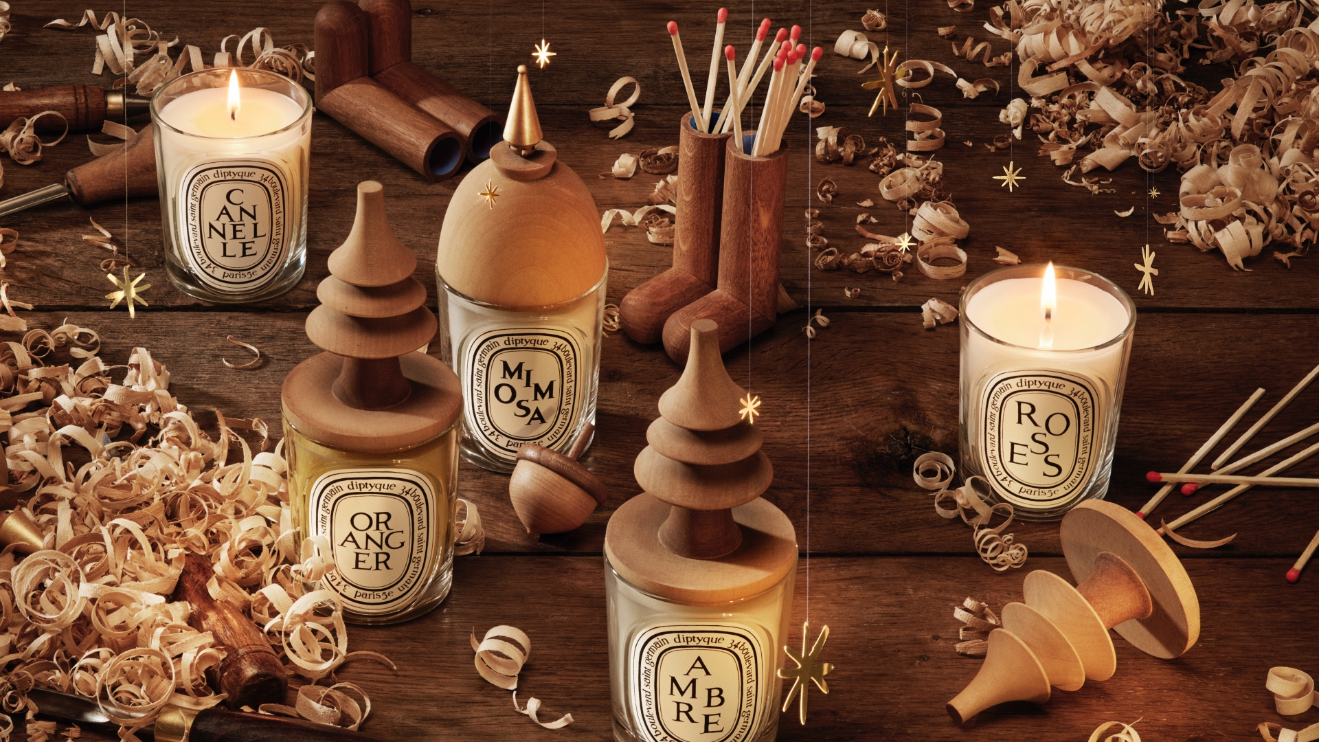 A classic Diptyque candle topped with a mischievous carved wooden elf lid accessory.