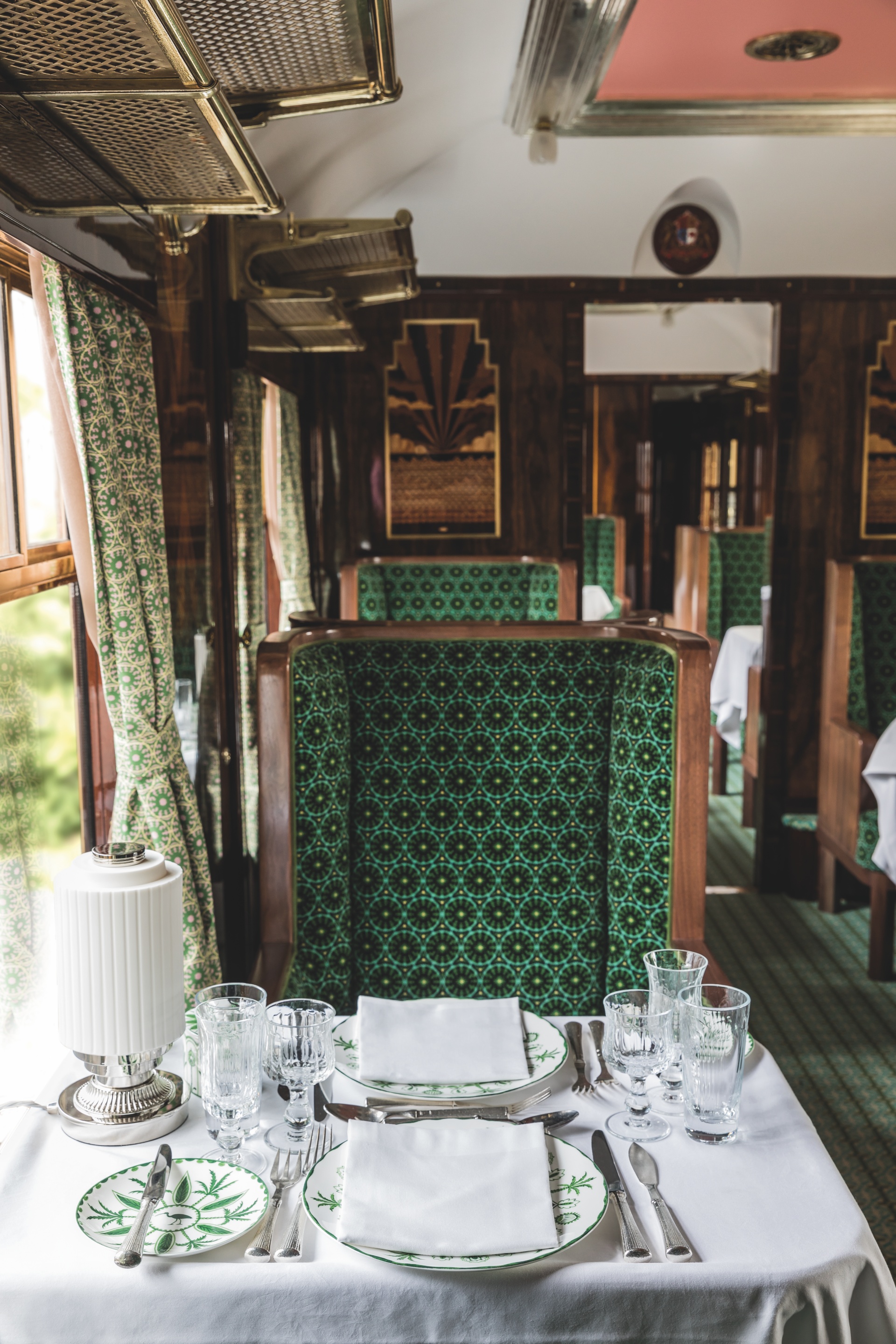 Modern art deco ceiling and custom green upholstery in the Wes Anderson train carriage